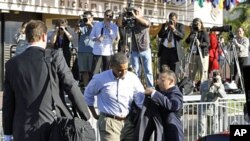 U.S. President Barack Obama dons his jacket before boarding Air Force One at Hickam Air Force Base in Honolulu November 15, 2011