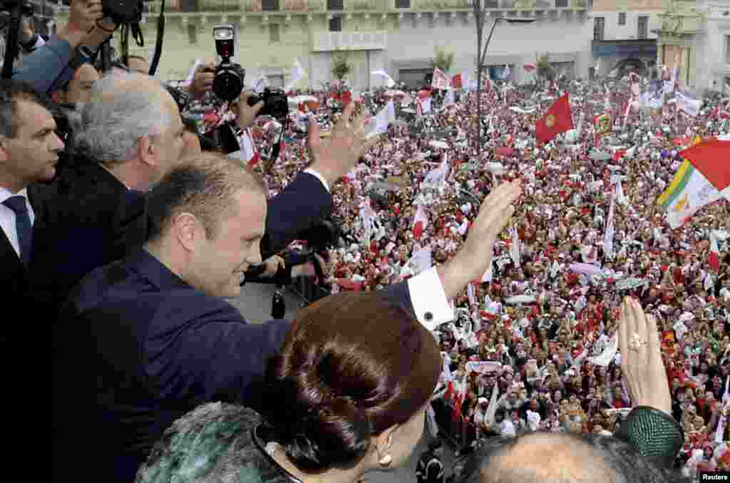 Malta&#39;s newly sworn-in Prime Minister and Labour Party leader Joseph Muscat waves to the crowds from the balcony of the Presidential Palace in Valletta. The Labour Party won a national election, returning to power after 15 years in opposition.