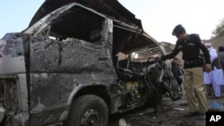 ایک پولیس آفیسر بدھ کے روز خودکش حملے میں تباہ ہونے والی ایک گاڑی کا معائنہ کررہا ہے۔ خیبر پختونخواہ کے شہر کوہاٹ میں ہونے والے اس حملے میں 16 افراد ہلاک ہوگئے۔