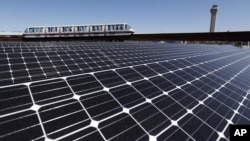 新泽西州纽瓦克自由国际机场的摆渡列车驶过新近安装的楼顶太阳能电池板。（2014年4月24日）