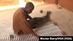 An artisan paints textiles in Mali’s capital, Bamako. Mali was suspended Jan. 1 from a trade program giving duty-free access to U.S. markets. (Moctar Barry/VOA)