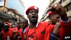 FILE - Musician turned politician Robert Kyagulanyi Ssentamu, center, is joined by other activists in Kampala, July 11, 2018.
