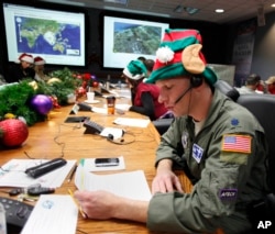 FILE - Air Force Lt. Col. David Hanson, of Chicago, takes a phone call from a child in Florida at the Santa Tracking Operations Center at Peterson Air Force Base near Colorado Springs, Colo., Dec. 24, 2014.