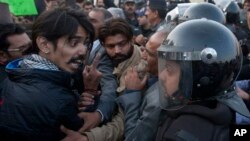 A civil society activist argues with police officers during a rally demanding recovery of the missing persons in Karachi, Pakistan, Thursday, Jan. 19, 2017. Pakistani police say a clash has been averted between the supporters of missing human rights activ