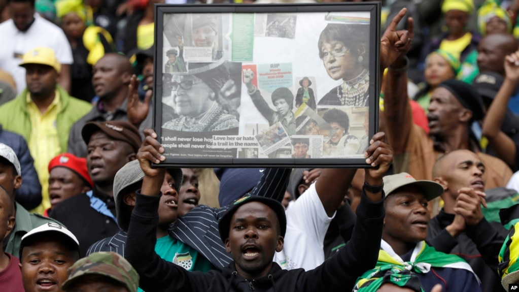 A man holds up a frame showing newspaper clippings of anti-apartheid activist Winnie Madikizela-Mandela during her memorial service at Orlando, Stadium, in Soweto, Apr. 11, 2018. 