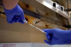 FILE PHOTO: A pharmacist fills a syringe with the Pfizer-BioNTech coronavirus disease (COVID-19) vaccine at Indiana University Health, Methodist Hospital in Indianapolis, Indiana, U.S., December 16, 2020. REUTERS/Bryan Woolston