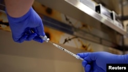 Seorang apoteker mengisi jarum suntik dengan vaksin Pfizer-BioNTech Covid-19 di Indiana University Health, Methodist Hospital di Indianapolis, Indiana, AS, 16 Desember 2020. (Foto: REUTERS/Bryan Woolston)