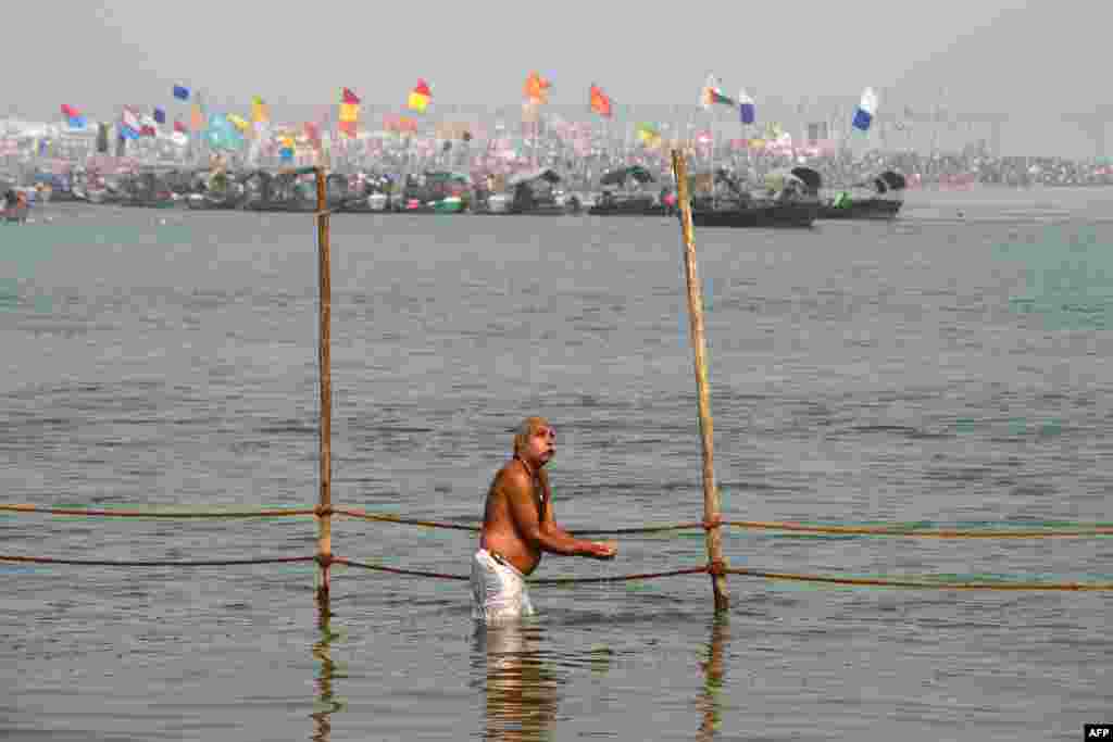 A devotee offers prayers as he takes a holy dip in the Ganges River to observe Paush Purnima festivities, which marks the beginning of the Magha month in the Hindu calendar, during the Magh Mela festival in Allahabad, India.