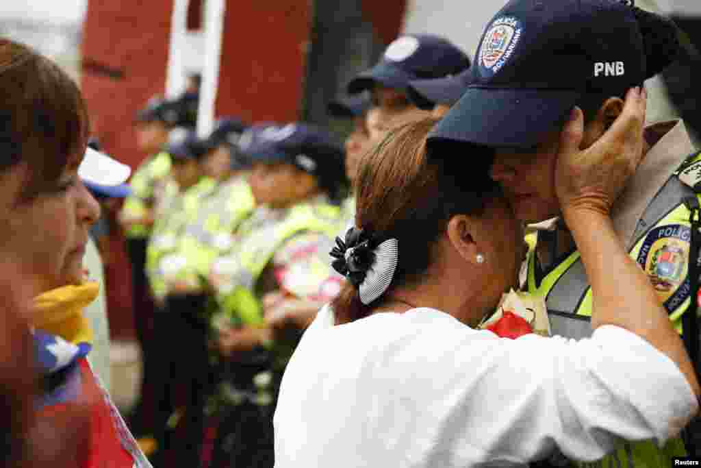 Una marcha de mujeres contra el gobierno de Nicolás Maduro en Venezuela, fue liderada por la opositora María Corina Machado. En la imagen, una mujer abraza a un agente del orden, en Caracas.&nbsp; 
