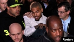 Singer Chris Brown (C) leaves the U.S. District Court in Washington, Oct. 28, 2013. 