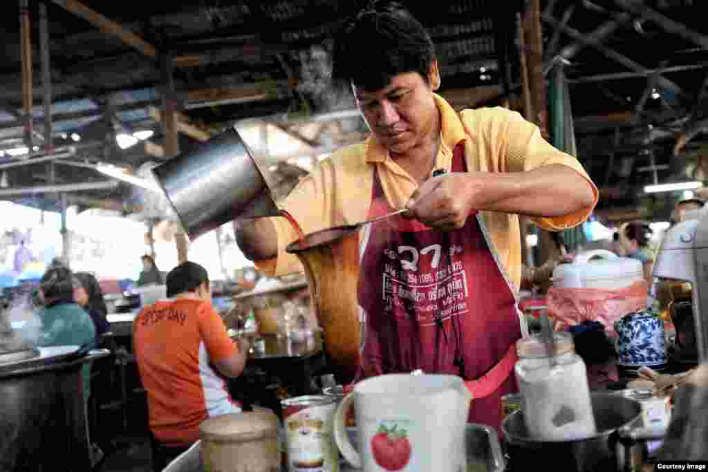 A man makes traditional Thai tea using a cloth bag filter at Bang Saphan meat and fish market in Prachuap Khiri Khan province, Thailand, April 4, 2015. (Photo taken by Matthew Richards)