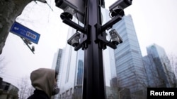 上海街头监控摄像机下的一名戴口罩的行人。（2020年3月4日）