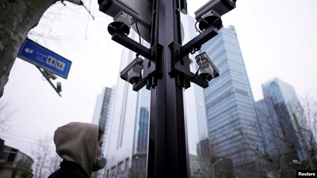 上海街头监控摄像机下的一名戴口罩的行人。(2020年3月4日)