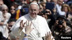 Pope Francis waves as he leaves after the Palm Sunday mass at Saint Peter's Square, March 24, 2013. 