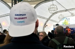 The European Solidarity Corps, a new initiative for young people to travel and help out people in difficulty across the continent, offered baseball caps to prospective enrollees outside the European Commission headquarters in Brussels, Belgium, Dec. 7, 2016.