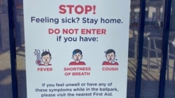 A sign outside of Nationals Park in Washington, D.C. tells baseball fans to stay away from the stadium if they do not feel well. (VOA/Dan Friedell)