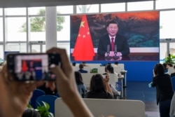 采访博鳌论坛的记者们在媒体厅观看屏幕上显示的中国国家主席习近平在开幕式上讲话的视频。（2021年4月20日）