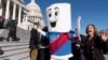 FILE - A man dressed as "Build Back Better Bill" wears a sash saying, "On to the Senate," Nov. 19, 2021, on Capitol Hill.