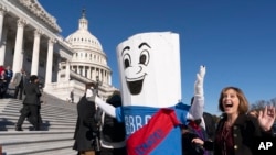 FILE - A man dressed as the "Build Back Better Bill" wears a sash saying, "on to the Senate," Nov. 19, 2021, on Capitol Hill.
