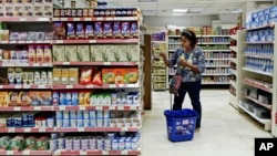 FILE - A woman shops at a supermarket in Cairo, Egypt. 