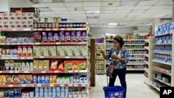 FILE - A woman shops at a supermarket in Cairo, Egypt. 