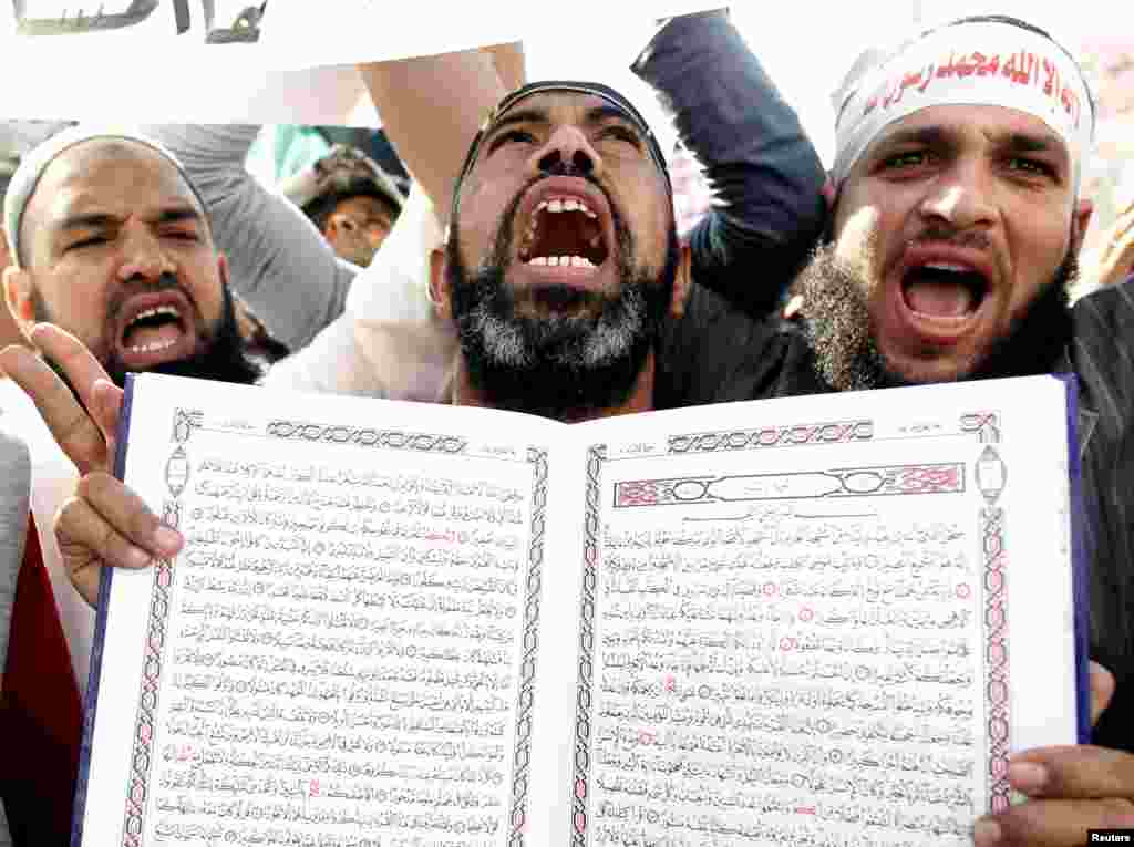 An Islamist Egyptian protester holds a Koran during a protest of hundreds of Salafists gathered for the enforcement of Islamic sharia law at Tahrir Square in Cairo November 9