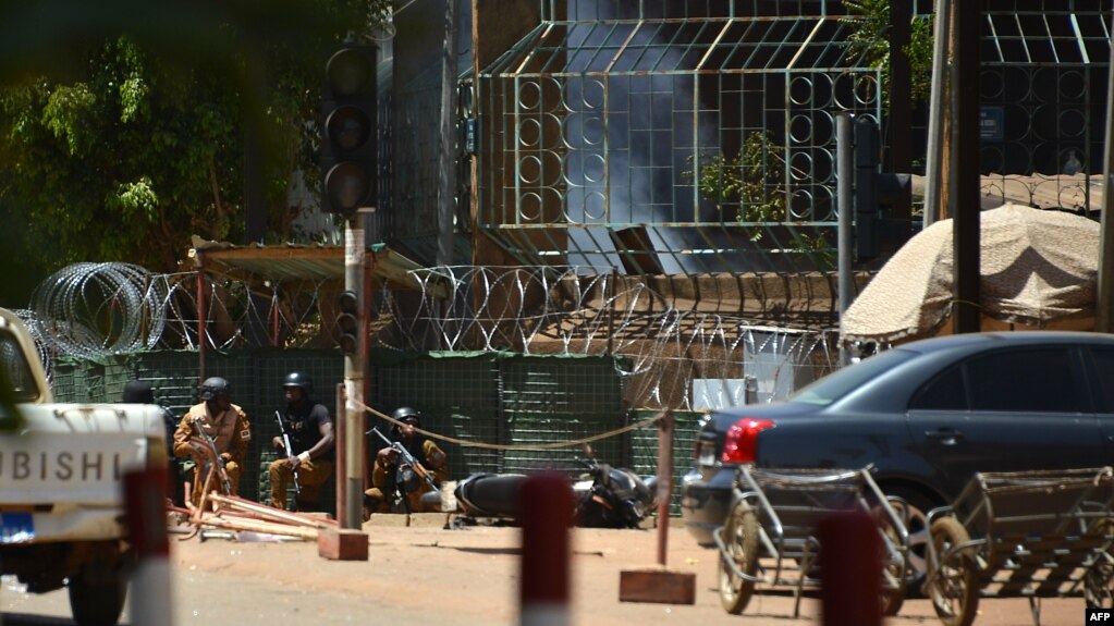 Des militaires se protègent alors que de la fumée s’échappe de l'Institut français de Ouagadougou, Burkina Faso, le 2 mars 2018