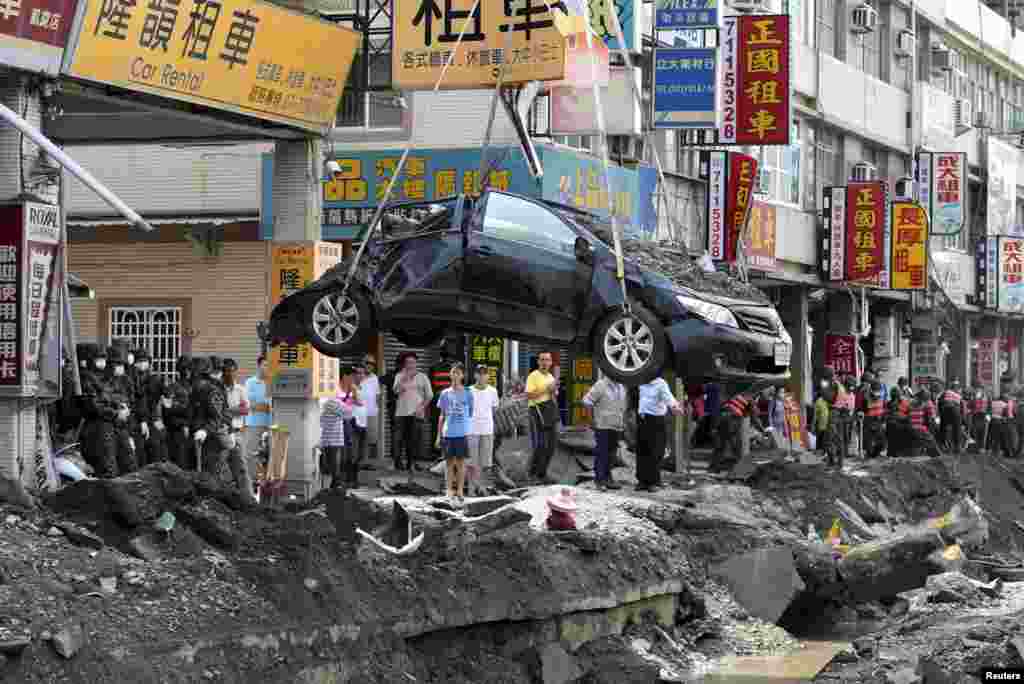 A damaged car is removed from the wreckage after an explosion in Kaohsiung, southern Taiwan, Aug. 2, 2014. A series of explosions caused by a gas leak killed 25 people and injured 267 in Taiwan's second city, sending flames shooting 15 stories into the air, setting ablaze entire blocks and reducing small shops to rubble.