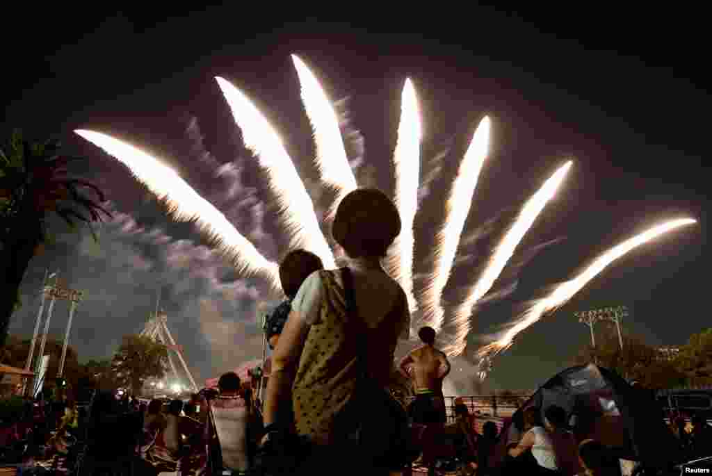 Visitors watch fireworks at Toshimaen amusement park in Tokyo, Japan.