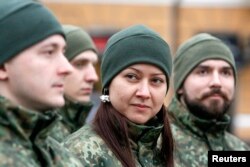 FILE - Members of the newly created Ukrainian interior ministry battalion "Saint Maria" prepare for military training, in Kyiv, Feb. 3, 2015.
