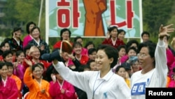 지난 2004년 5월 평양에서 열린 6.15 공동선언 실천을 위한 남북 노동자 통일대회에서, 북한 노동자(왼쪽)와 한국 노동자가 손을 잡고 함께 달리고 있다. (자료사진)