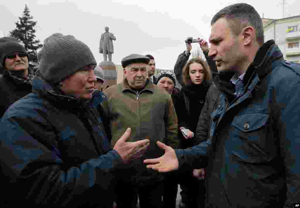 Ukrainian lawmaker and chairman of the Ukrainian party Udar (Punch), former WBC heavyweight boxing champion Vitali Klitschko, right, speaks with locals in Donetsk, Ukraine, March 9, 2014.&nbsp;