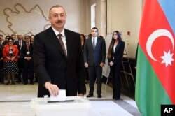 FILE - Azerbaijan President Ilham Aliyev casts his ballot at a polling station during presidential elections in Baku, Azerbaijan, April 11, 2018.