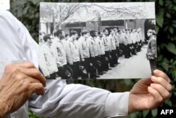Tran Trong Duyet, l'ancien directeur de la prison d'Hanoï, tient une photo des prisonniers américains, au Vietnam, le 3 janvier 2018.