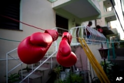 Idamelys Moreno's boxing gloves hang on a line to dry, after a training session in Havana, Cuba, Jan. 19, 2017.