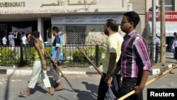 Protesters, armed with sticks, gather in front of the Luxor governorate building to protest the appointment of Adel Mohamed al-Khayat as governor, Luxor, June 19, 2013.