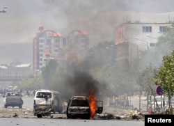 A vehicle is seen on fire after a blast near the Afghan parliament in Kabul, Afghanistan, June 22, 2015.