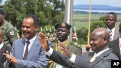 Ugandan President Yoweri Museveni (R) and Eritrean President Isaias Afewerki wave as Afewerki arrived in Uganda for a three-day visit, August 16, 2011