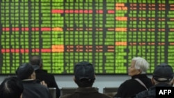 Investors look at a screen showing stock market movements at a securities company in Hangzhou in China's eastern Zhejiang province on February 3, 2020. - Chinese stocks crashed on February 3 with some major shares quickly falling by the maximum daily limi
