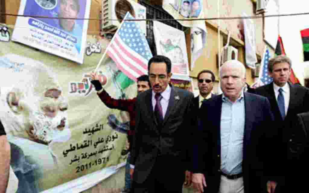 US Rebuplican senator John McCain (R) walks with Abdul Hafiz Ghoqa, spokesman of the Libyan National Transitional Council (NTC), during his tour to the rebel headquarters in their eastern stronghold city of Benghazi , April 22, 2011