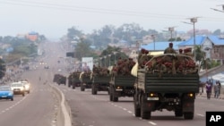 FILE - Congo military trucks carrying Congolese troops drive in a main street after violence erupted due to the delay of the presidential elections in Kinshasa, Democratic Republic of Congo, Tuesday, Sept. 20, 2016.