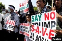 Kelompok-kelompok Muslim membawa poster berdemonstrasi di luar Kedutaan Besar Amerika di Jakarta, memprotes keputusan Presiden Trump mengakui Yerusalem sebagai Ibu Kota Israel, 8 Desember 2017.
