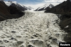 FILE - Meltwater flows over the Laohugou No. 12 glacier in the Qilian mountains, Subei Mongol Autonomous County in Gansu province, China, Sep. 27, 2020.