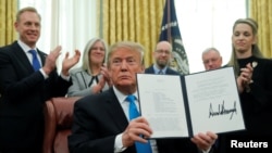 U.S. President Donald Trump displays the "Space Policy Directive 4" after signing the directive to establish a Space Force as the sixth branch of the Armed Forces in the Oval Office at the White House in Washington, U.S., February 19, 2019. REUTERS/Jim Young - RC191053A710 