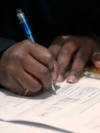 FILE - A job seeker fills out an application during a National Career Fairs job fair, in Chicago, Illinois. A tightening job market in Canada means international students in Canada are having difficulty finding work.