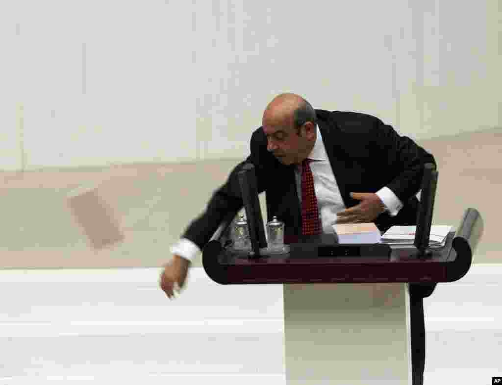 Seorang anggota DPR Turki, Hasip Kaplan melempar buku rancangan anggaran pemerintah 2014 saat memberikan pidato di gedung parlemen di Ankara, Turki. 