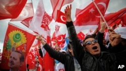 8일 터키 이스탄불에서 진행된 개헌찬성 집회 참가자들이 레제프 타이이프 에르도안 대통령의 얼굴(왼쪽)이 그려진 깃발과 터키 국기를 흔들며 소리치고 있다.