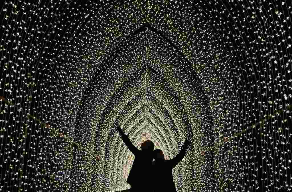 Children walk through the Cathedral of Light in London.