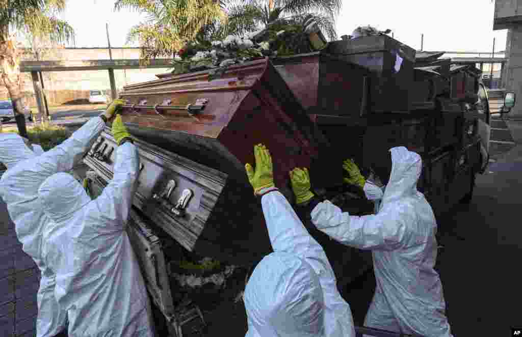 Workers collect and stack the coffins of people who have been recently cremated, at La Recoleta cemetery, amid the new coronavirus pandemic in Santiago, Chile, June 30, 2020.&nbsp;The coffins are&nbsp; destroyed by a company specializing in organic waste.&nbsp;