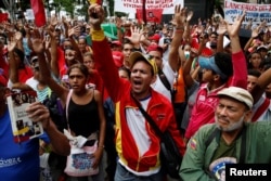 FILE - Supporters of Venezuela's President Nicolas Maduro shout as they attend a rally against the application of Organization of American States (OAS) democratic charter, in Caracas, Venezuela, June 23, 2016.